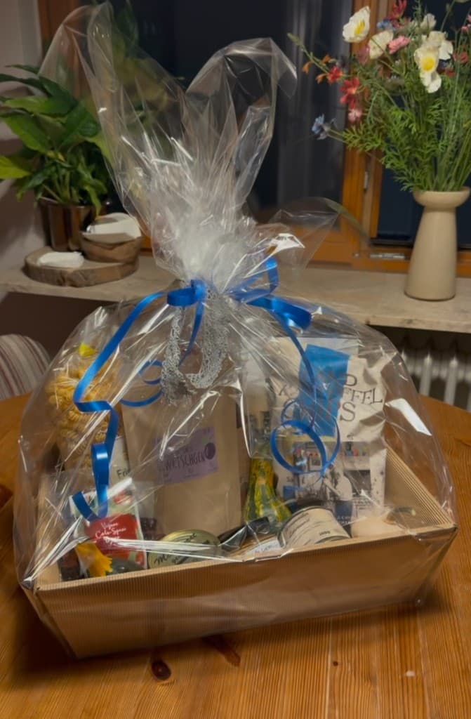 Beispiel eines gepackten Geschenkkorbs mit Folie und Schleife